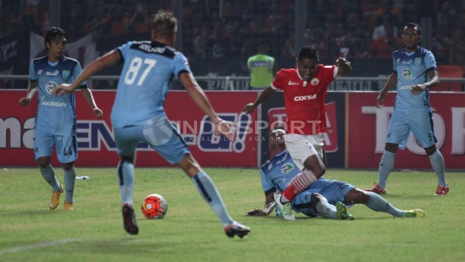 Pemain Persija Jakarta, Ramdani Lestaluhu (tengah) dilanggar pemain Persela Lamongan.